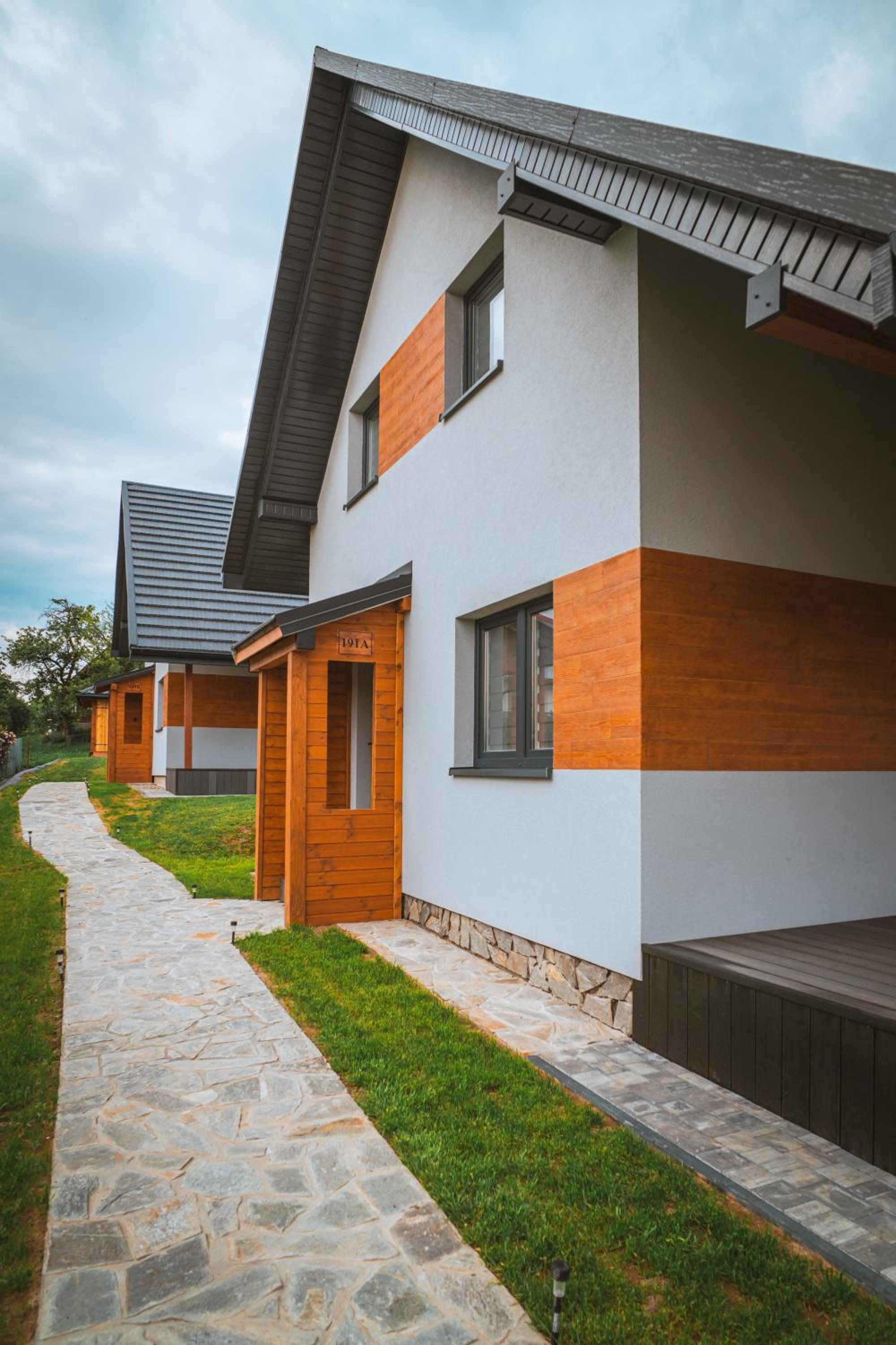 Dom z drewnianymi elementami i kamienną ścieżką w dzień